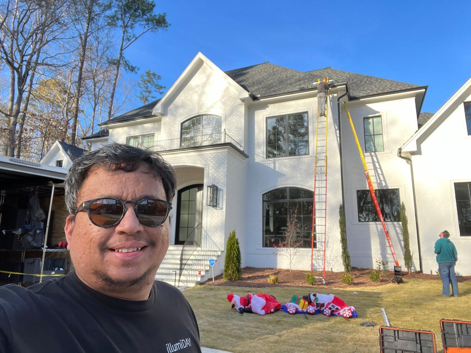 Installers on ladders putting up christmas lights