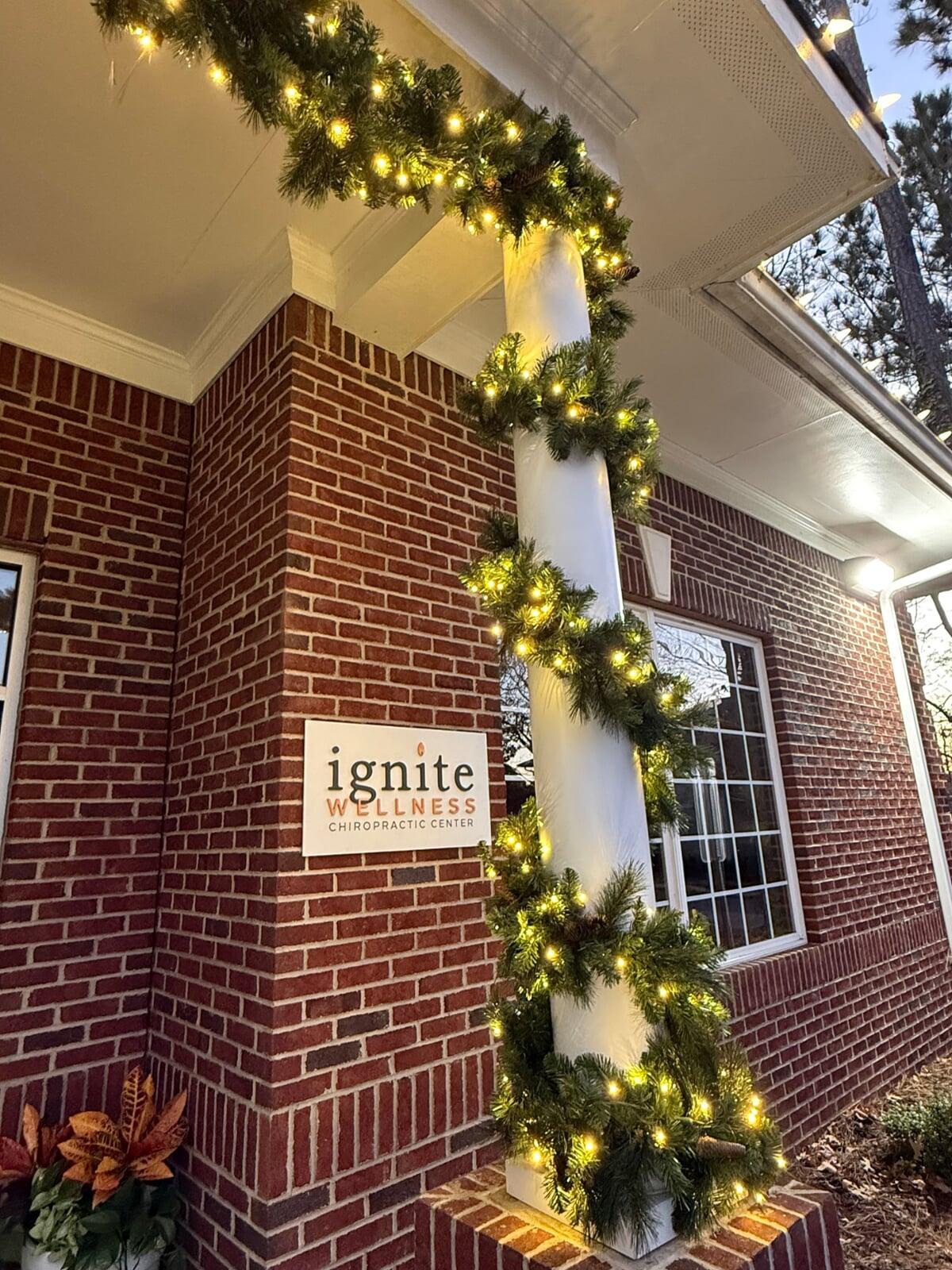 Column wrapped in lit garland in front of a clinic