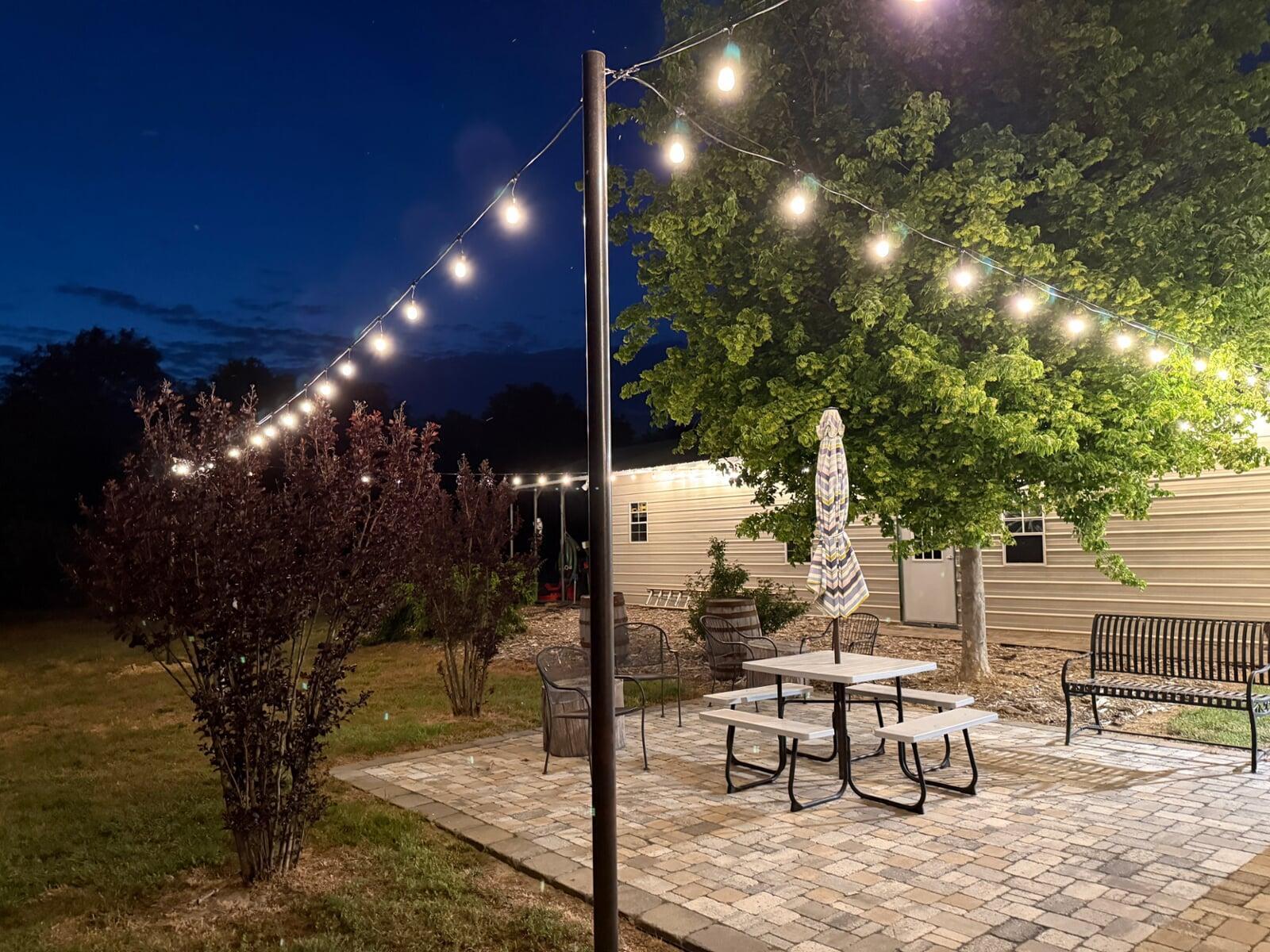 Patio at night with string lights surrounding the area providing illumination