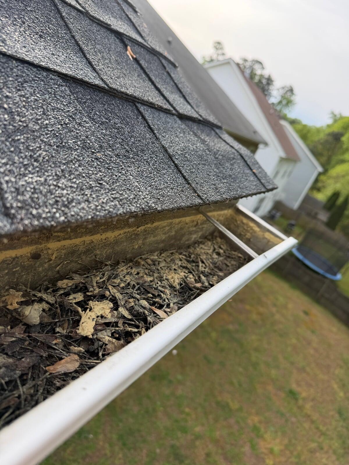 Image of a gutter that is filled with debris