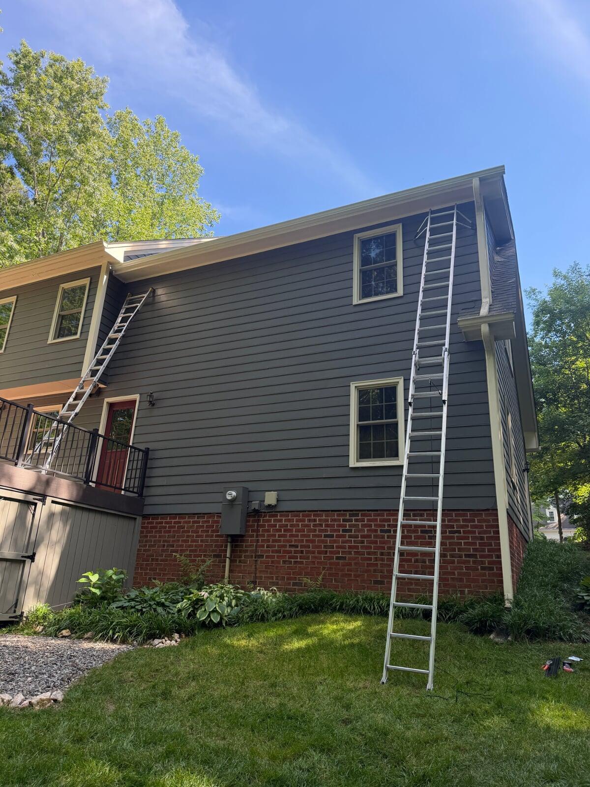 Image of two ladders propped on the side of a house